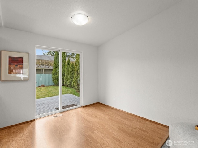 empty room featuring visible vents, baseboards, and light wood-style flooring