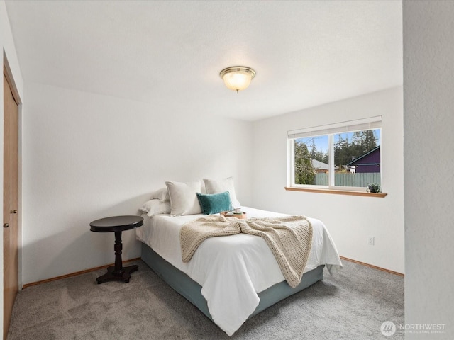 bedroom featuring baseboards and carpet