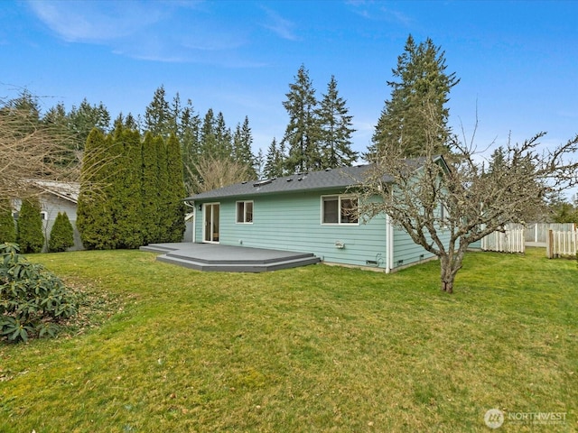 back of property featuring a yard, a deck, and fence