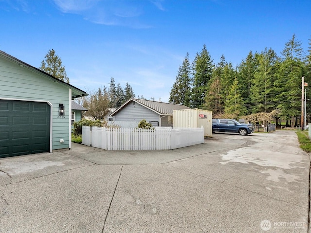 garage with driveway and fence