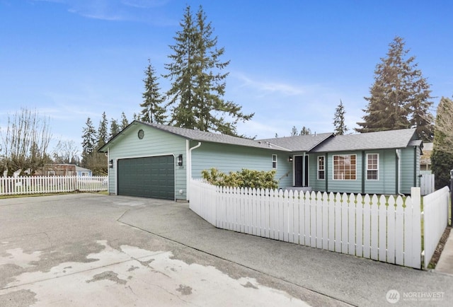 single story home with driveway, an attached garage, and fence