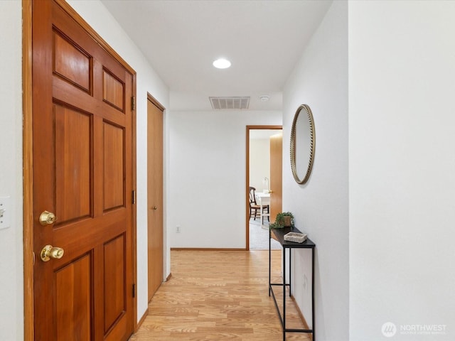 corridor featuring light wood-type flooring, visible vents, baseboards, and recessed lighting