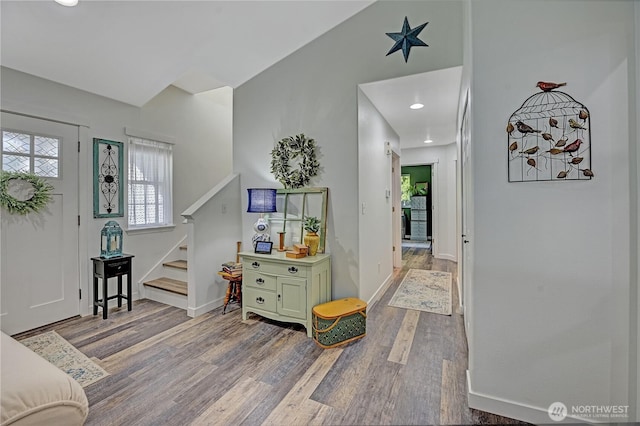 entryway featuring stairs, vaulted ceiling, wood finished floors, and baseboards