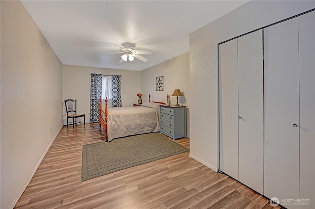 bedroom with a ceiling fan, baseboards, and light wood-type flooring