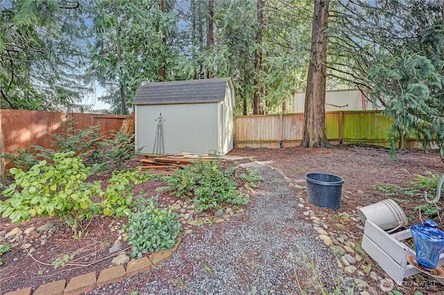 view of yard featuring a fenced backyard, a storage unit, and an outdoor structure