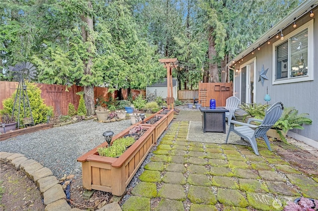 view of patio featuring a vegetable garden and fence private yard