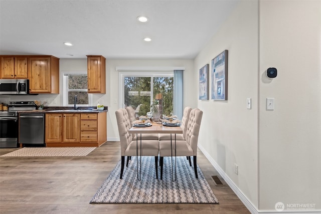 dining space with recessed lighting, wood finished floors, visible vents, and baseboards