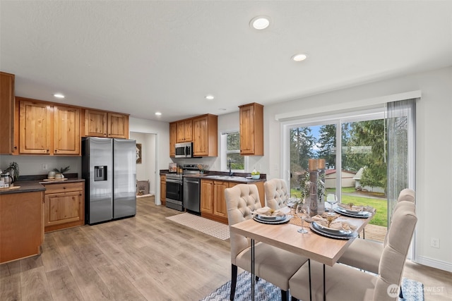 kitchen featuring dark countertops, recessed lighting, light wood-type flooring, and stainless steel appliances