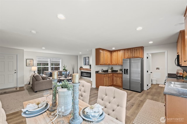 kitchen featuring dark countertops, open floor plan, recessed lighting, and stainless steel fridge