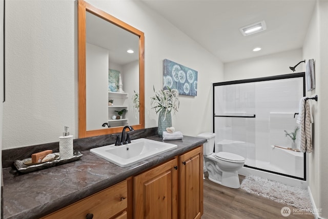 full bathroom featuring a shower stall, toilet, recessed lighting, wood finished floors, and vanity