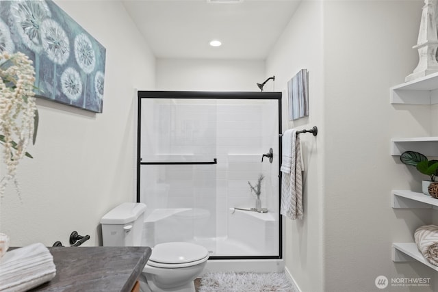 bathroom with visible vents, vanity, toilet, and a shower stall