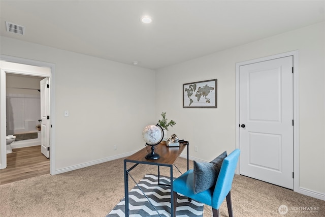 home office with visible vents, baseboards, and light colored carpet