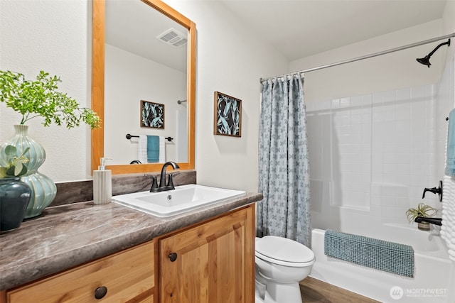 bathroom featuring visible vents, toilet, shower / tub combo with curtain, and vanity