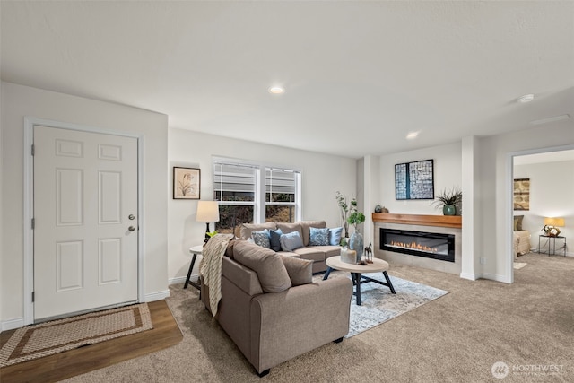 living area with recessed lighting, baseboards, and a glass covered fireplace