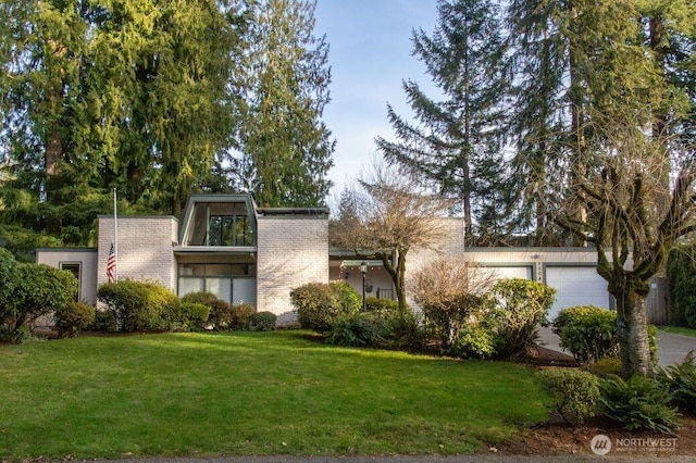 view of front of property with an attached garage and a front lawn