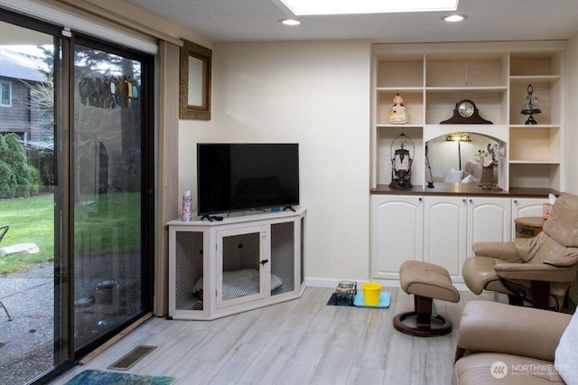 living area featuring recessed lighting, visible vents, and wood finished floors