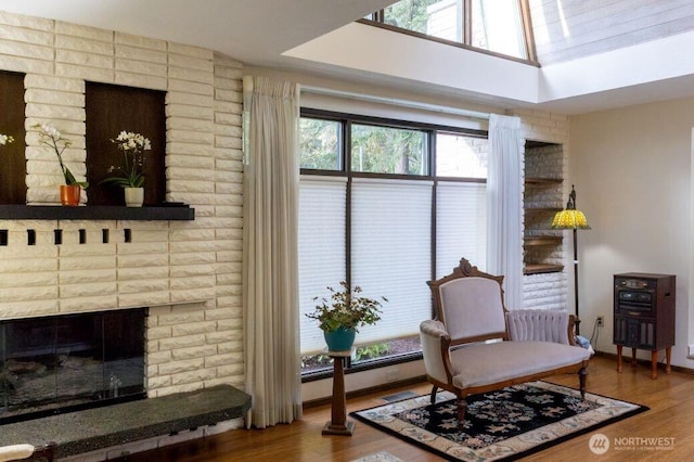 sitting room featuring a fireplace, wood finished floors, and baseboards