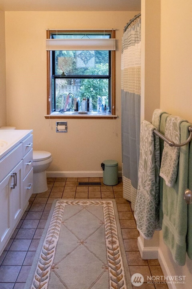 bathroom with visible vents, a shower with curtain, toilet, baseboards, and vanity