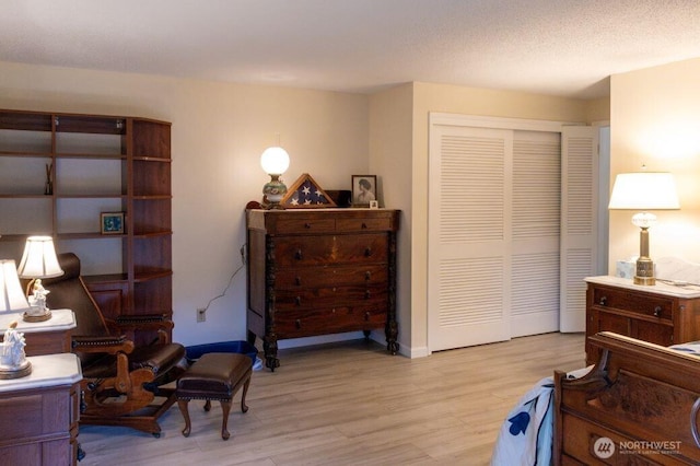 sitting room featuring a textured ceiling and light wood-style flooring