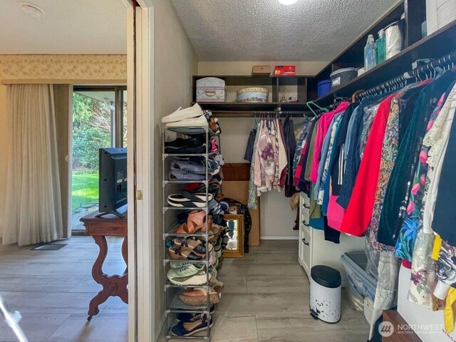 walk in closet with wood finished floors