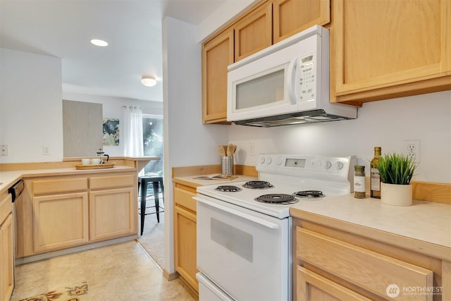 kitchen with white appliances, light brown cabinetry, and light countertops