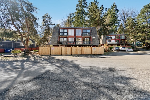 view of front of property featuring uncovered parking and fence