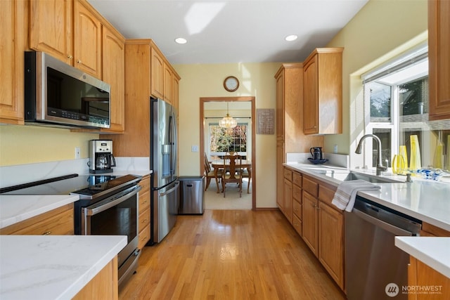 kitchen featuring light wood-type flooring, stainless steel appliances, a sink, and recessed lighting