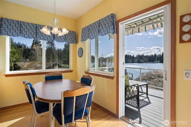 dining area with a chandelier, wood finished floors, and baseboards