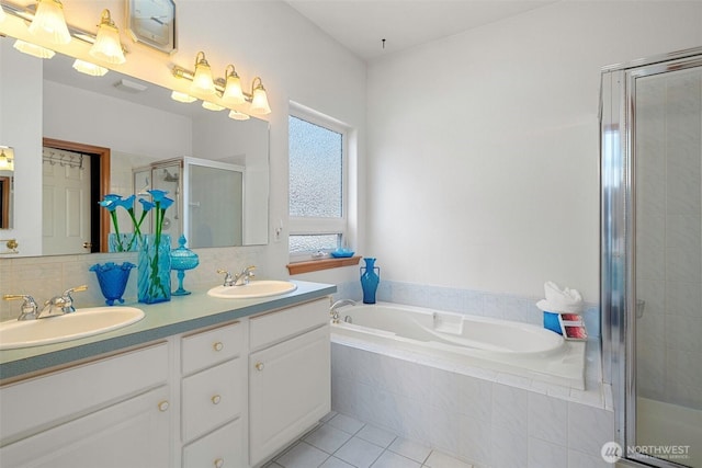 full bathroom with double vanity, a sink, a bath, and a shower stall