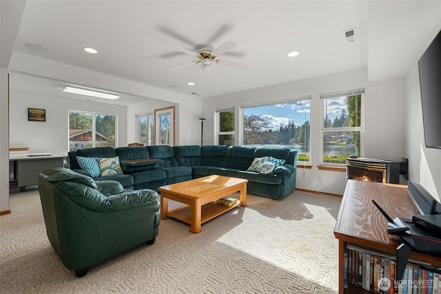 living room featuring recessed lighting, plenty of natural light, visible vents, and light colored carpet