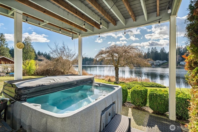 view of pool featuring a water view and a hot tub