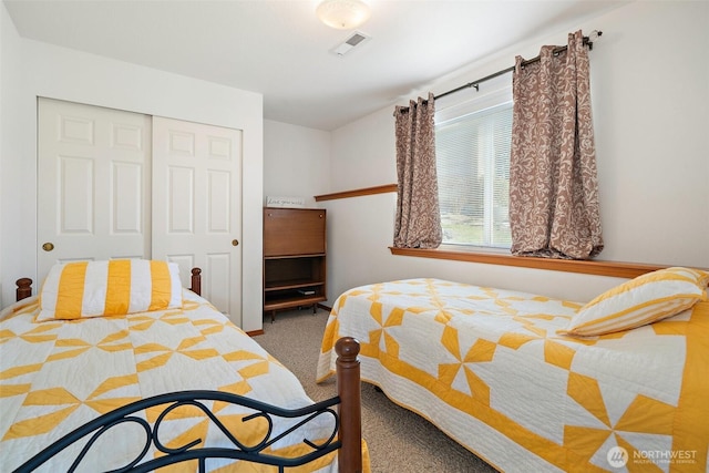 bedroom with a closet, visible vents, and carpet flooring