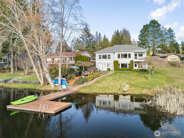 rear view of house featuring a yard and a water view