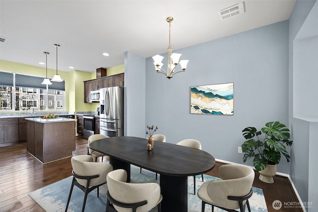 dining area featuring dark wood-style floors, visible vents, baseboards, recessed lighting, and a notable chandelier