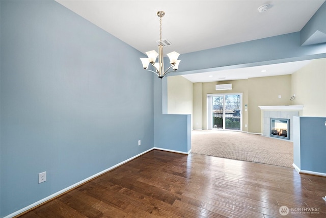 unfurnished living room featuring visible vents, a tile fireplace, baseboards, and wood finished floors