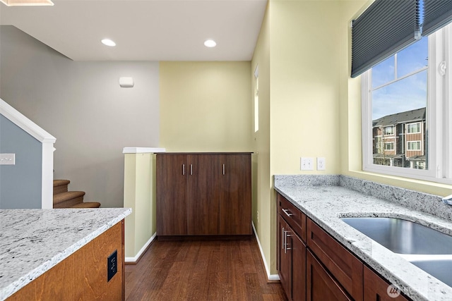 kitchen with baseboards, light stone counters, recessed lighting, dark wood-style floors, and a sink