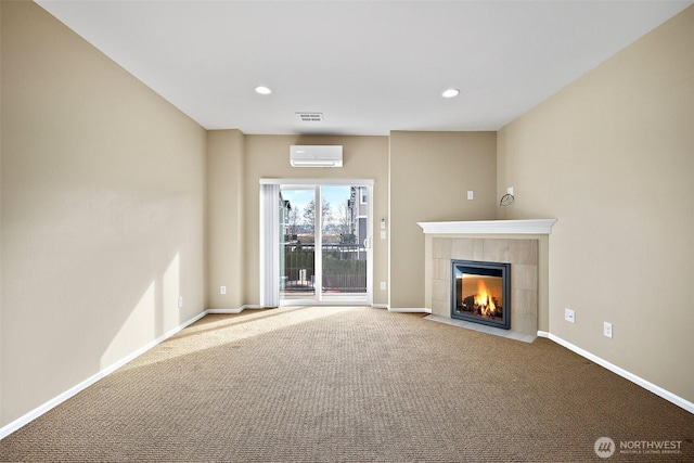 unfurnished living room featuring a wall mounted air conditioner, recessed lighting, carpet floors, baseboards, and a tile fireplace