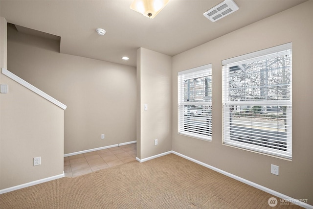 spare room featuring visible vents, recessed lighting, light tile patterned floors, baseboards, and light colored carpet