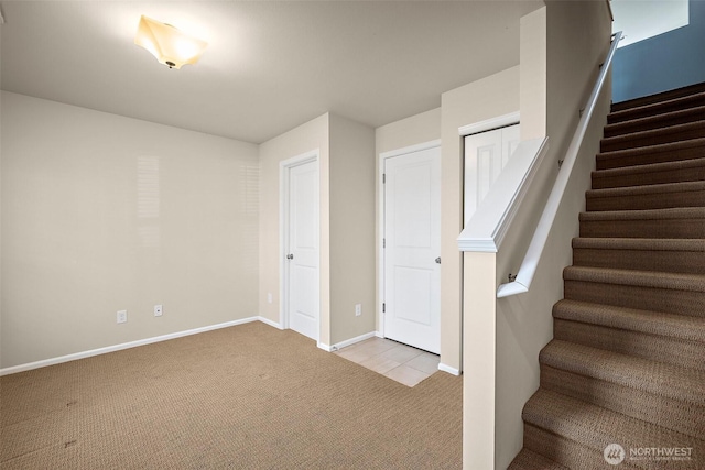 below grade area with baseboards, carpet, and stairs