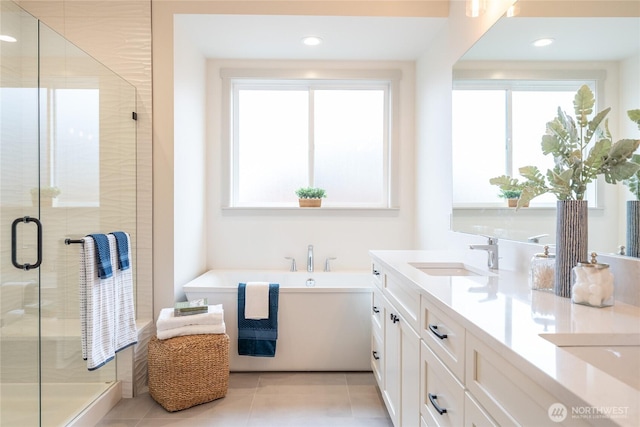 bathroom with double vanity, a healthy amount of sunlight, a stall shower, and a sink