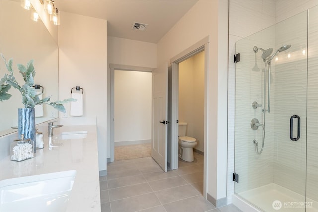 bathroom featuring a sink, visible vents, toilet, and a shower stall