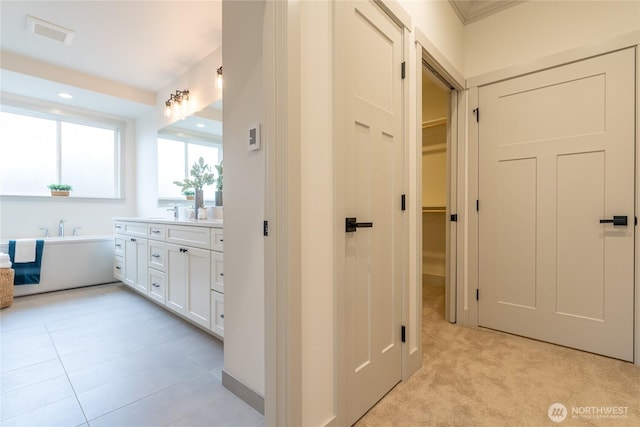 hallway featuring light carpet, visible vents, and recessed lighting