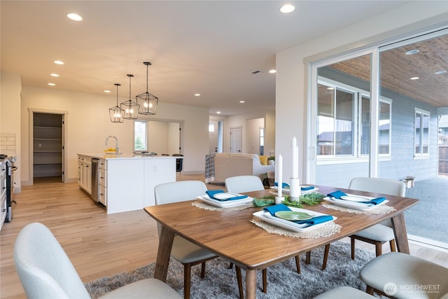 dining area with light wood-style flooring and recessed lighting