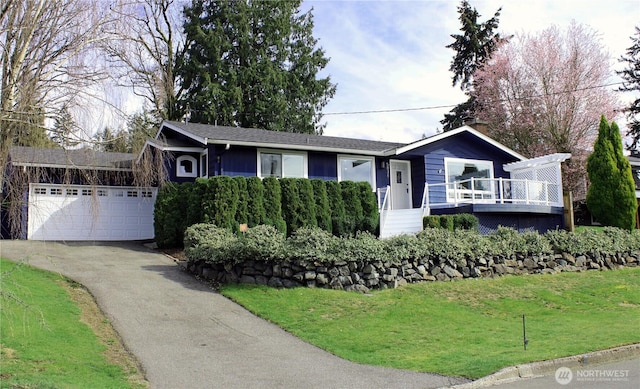 single story home with a deck, a front yard, a garage, and driveway