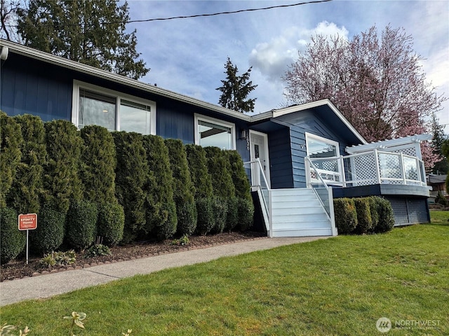 view of front of house featuring a front lawn, stairway, and a wooden deck