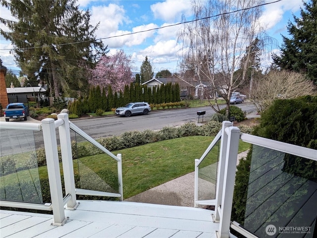 wooden terrace featuring a lawn