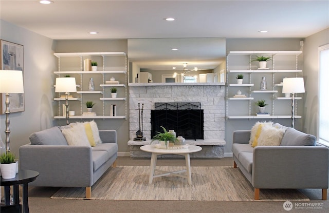 living room featuring recessed lighting and a fireplace with raised hearth