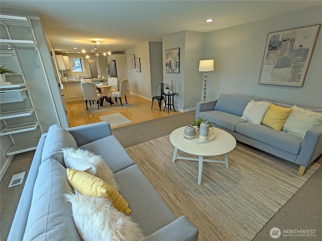 living room with a chandelier, visible vents, recessed lighting, and baseboards