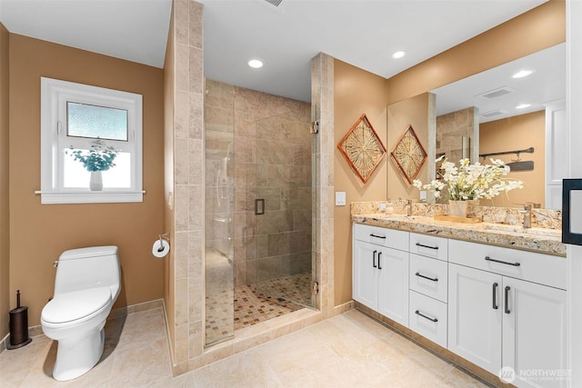 full bathroom featuring double vanity, a sink, a shower stall, tile patterned floors, and toilet