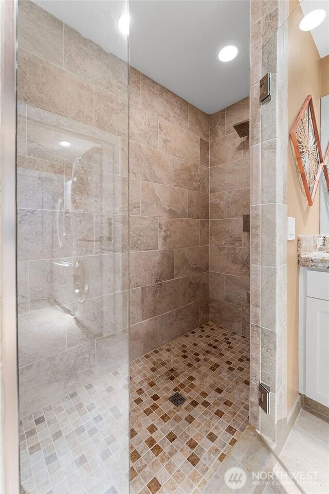 full bath with a stall shower and vanity